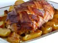 Arista di maiale alla birra, un piatto fatto in casa da Benedetta, avvolta in pancetta croccante e servita con patate dorate.