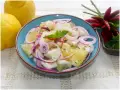 Fresca insalata di limoni, pompelmo, cipolla rossa e peperoncino, guarnita con menta.