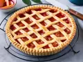 Crostata con ripieno di frutta e una griglia di pasta frolla, perfetta dimostrazione di come mettere le strisce sulla crostata.