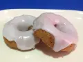 Due ciambelle con glassa di zucchero bianca e lucida, perfette per chi vuole imparare come fare la glassa di zucchero.