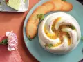 Dolce cremoso con cuore di frutto della passione, guarnito con biscotti e menta.