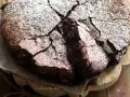 Torta fondente al cioccolato, con una crosta screpolata e cosparsa di zucchero a velo, pronta per essere gustata.
