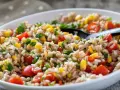 Insalata di farro colorata con pomodorini, mais e prezzemolo fresco. Un piatto leggero e gustoso.