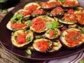 Fette di melanzane grigliate condite con salsa di pomodoro e basilico, un piatto gustoso di melanzane alla pizzaiola.