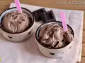 Due coppette di cremoso gelato al cioccolato, guarnito con scaglie, pronto da gustare. Un delizioso gelato cioccolato senza gelatiera.