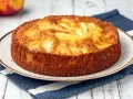 Torta di mele dorata, appena sfornata, con mele a vista. Perfetta da spennellare con un po' di sciroppo.