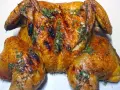 Un succulento pollo alla brace, dorato e profumato, condito con erbe aromatiche e aglio.