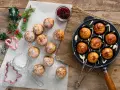 Frittelle dolci in padella, spolverate di zucchero a velo, pronte per essere gustate con marmellata.