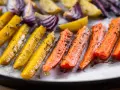Carote, cipolle rosse e patate dorate, un tripudio di verdure al forno, condite con erbe aromatiche e olio.