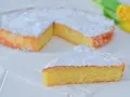Una deliziosa torta caprese senza mandorle, spolverata di zucchero a velo, con una fetta tagliata.