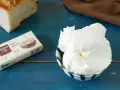 Burro montato in una ciotola, pronto per essere spalmato sul pane. La confezione di burro salato è accanto.