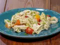 Piatto di insalata di trippa condita con erbe aromatiche, peperoncino e verdure colorate.