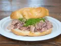 Panino con lampredotto, un classico street food fiorentino. La ricetta prevede trippa di bovino cotta e servita in un panino morbido con salsa verde.