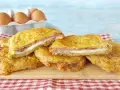 Fette dorate di melanzane alla pullastiello, ripiene di formaggio filante e salumi, pronte per essere gustate.