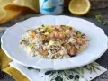 Un invitante risotto allo scoglio, ricco di cozze, gamberi e calamari, guarnito con scorza di limone.
