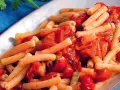 Un piatto invitante di pasta con i peperoni alla pugliese, condita con pomodoro fresco e prezzemolo.