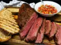 Spinacino di manzo succulento, affettato e servito con pane grigliato e salsa fresca. Ecco come cucinarlo per un pasto perfetto.
