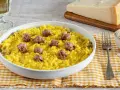 Un invitante risotto alla monzese, giallo intenso e ricco di saporiti pezzi di salsiccia, pronto per essere gustato.