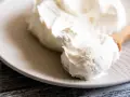 Crema bianca e soffice su un piatto, pronta per essere usata come ingredienti per mascarpone.