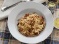 Un piatto di risotto alla pilota cremoso, con pezzetti di salsiccia, pronto per essere gustato.