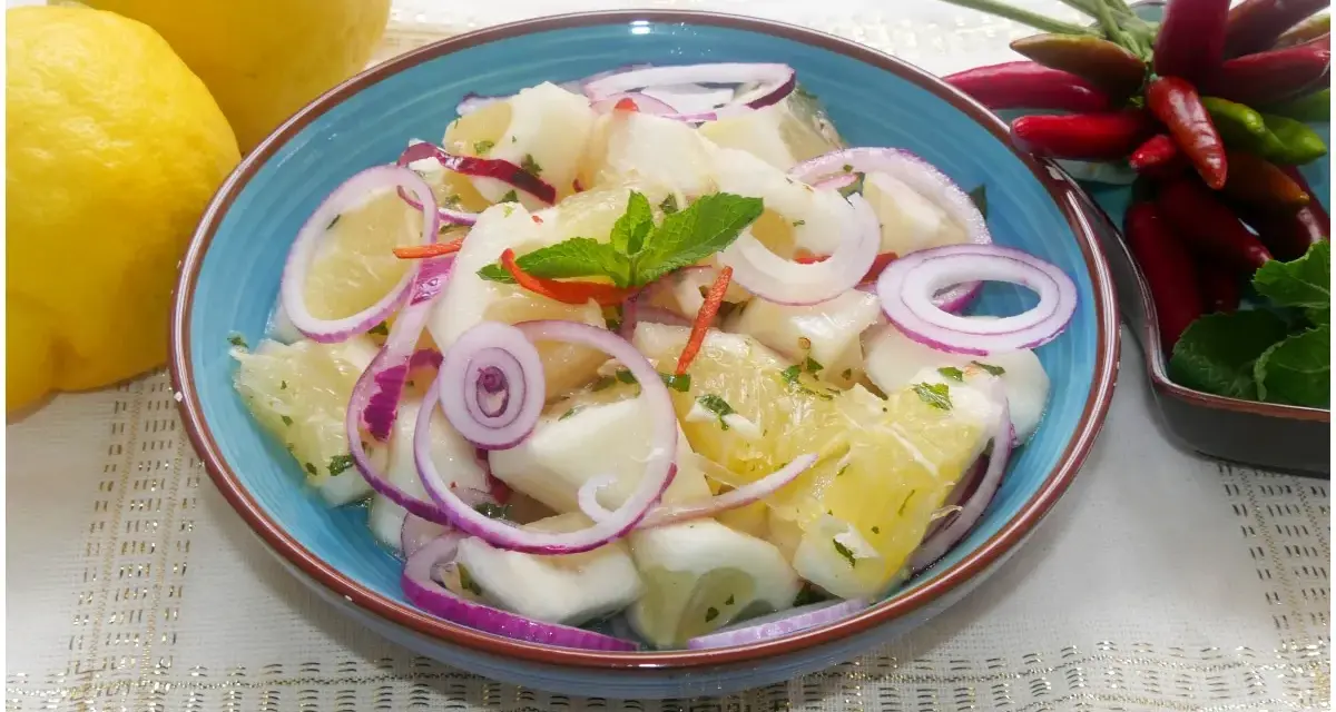 Fresca insalata di limoni, pompelmo, cipolla rossa e peperoncino, guarnita con menta.