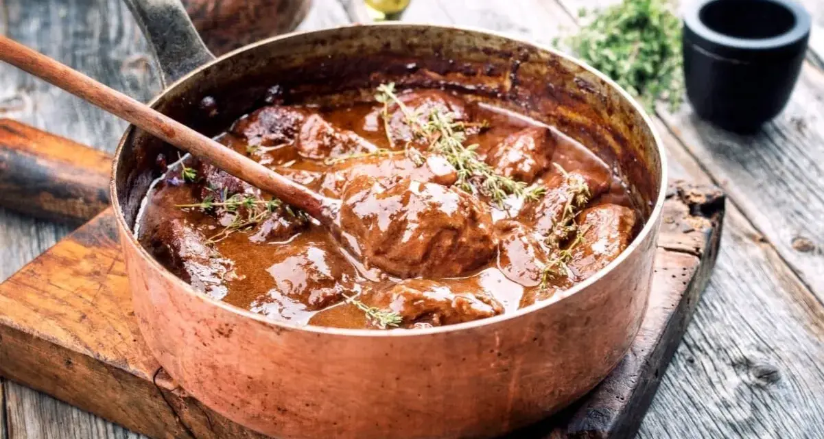 Succulento brasato ricetta semplice in una pentola di rame, pronto per essere servito.