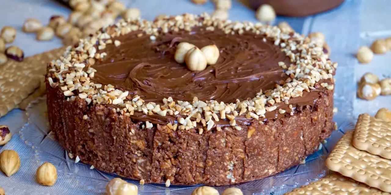 Torta Nutella 3 ingredienti: golosa e facile, con croccante base di biscotti e nocciole, ricoperta di crema alla nocciola e granella.