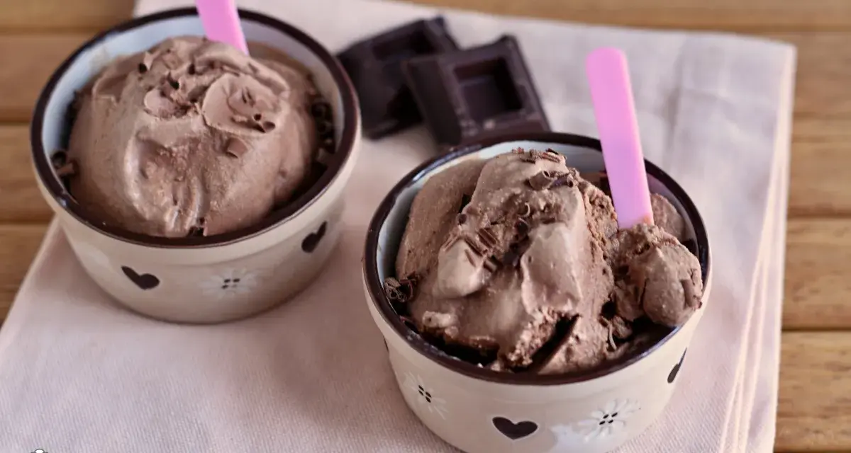 Due coppette di cremoso gelato al cioccolato, guarnito con scaglie, pronto da gustare. Un delizioso gelato cioccolato senza gelatiera.