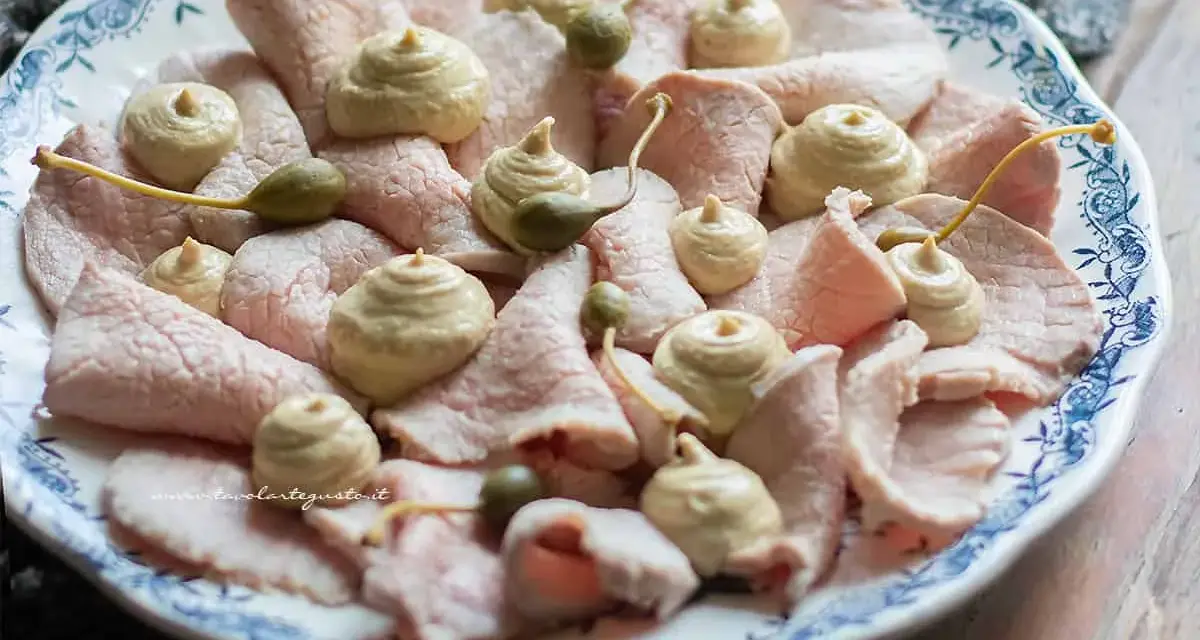 Vitello tonnato ricetta originale piemontese: fettine sottili di vitello rosa, guarnite con salsa tonnata e capperi.