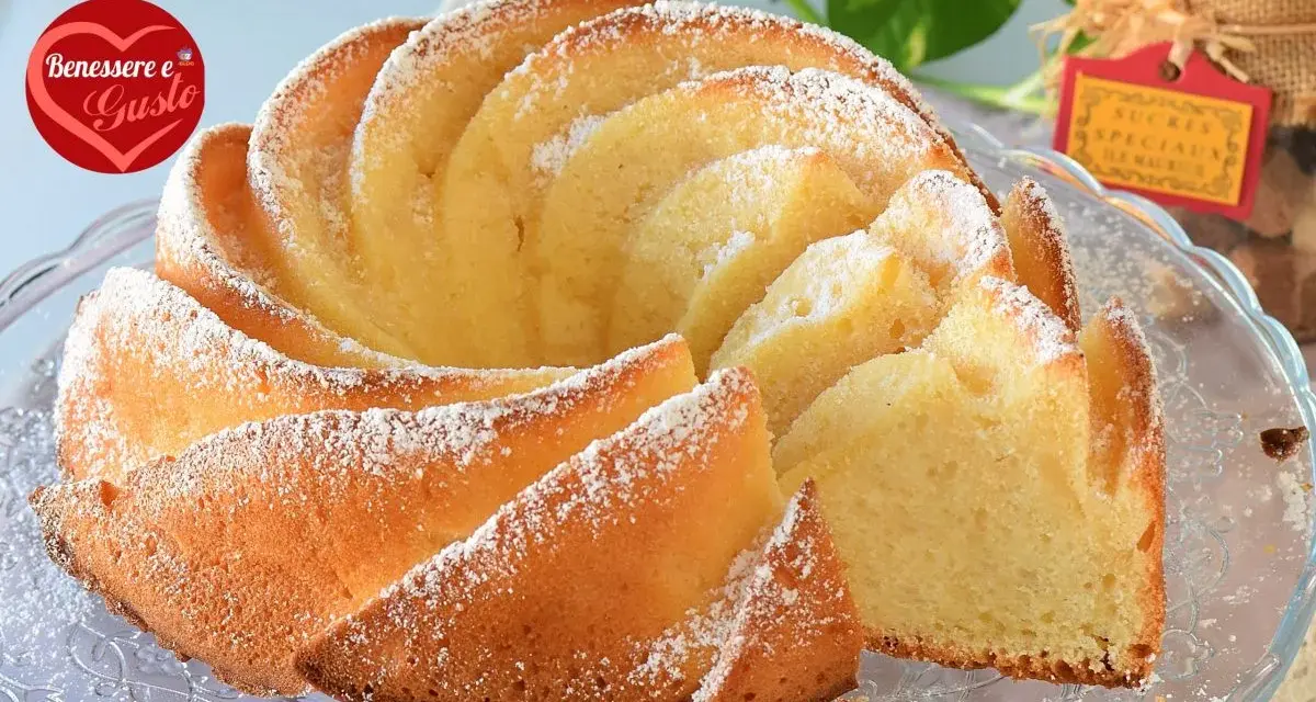 Un soffice ciambellone allo yogurt greco, spolverato di zucchero a velo, pronto per essere gustato.