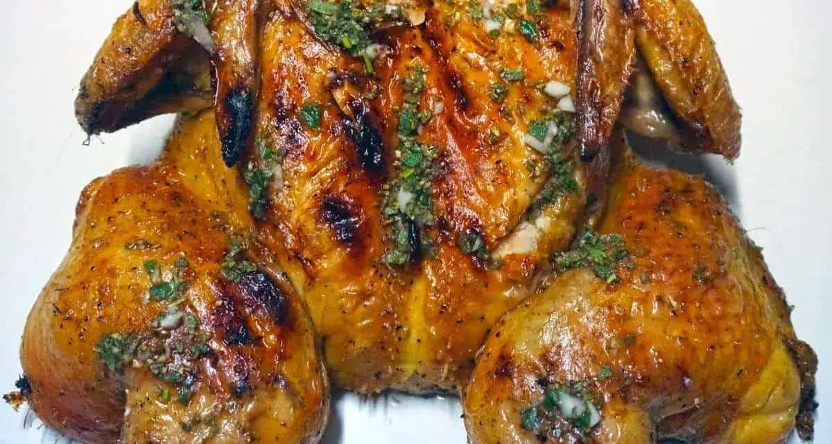Un succulento pollo alla brace, dorato e profumato, condito con erbe aromatiche e aglio.