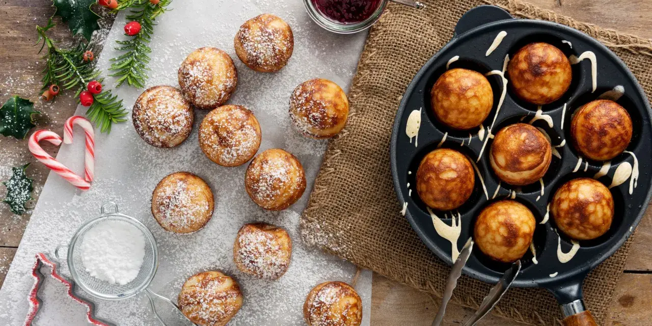 Frittelle dolci in padella, spolverate di zucchero a velo, pronte per essere gustate con marmellata.