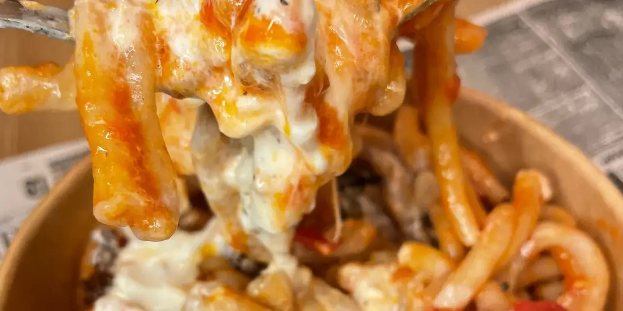 Primo piatto cremoso di pasta alla checca, con pomodoro e mozzarella filante, servito in un contenitore da asporto.