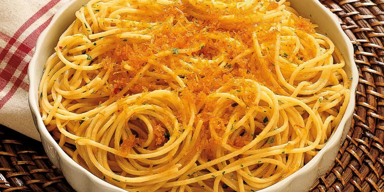 Spaghetti alla bottarga, un piatto saporito con pasta dorata e una generosa spolverata di uova di pesce essiccate.