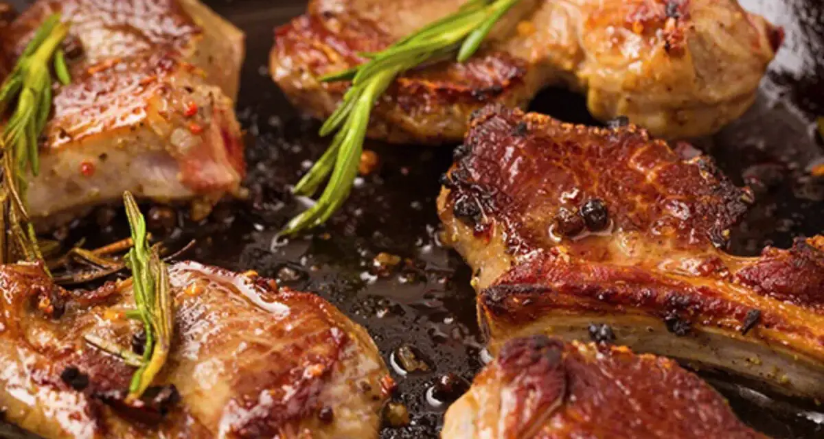 Succulento agnello in padella, dorato e profumato con rosmarino e pepe.