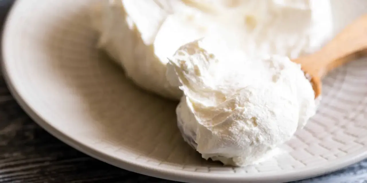 Crema bianca e soffice su un piatto, pronta per essere usata come ingredienti per mascarpone.