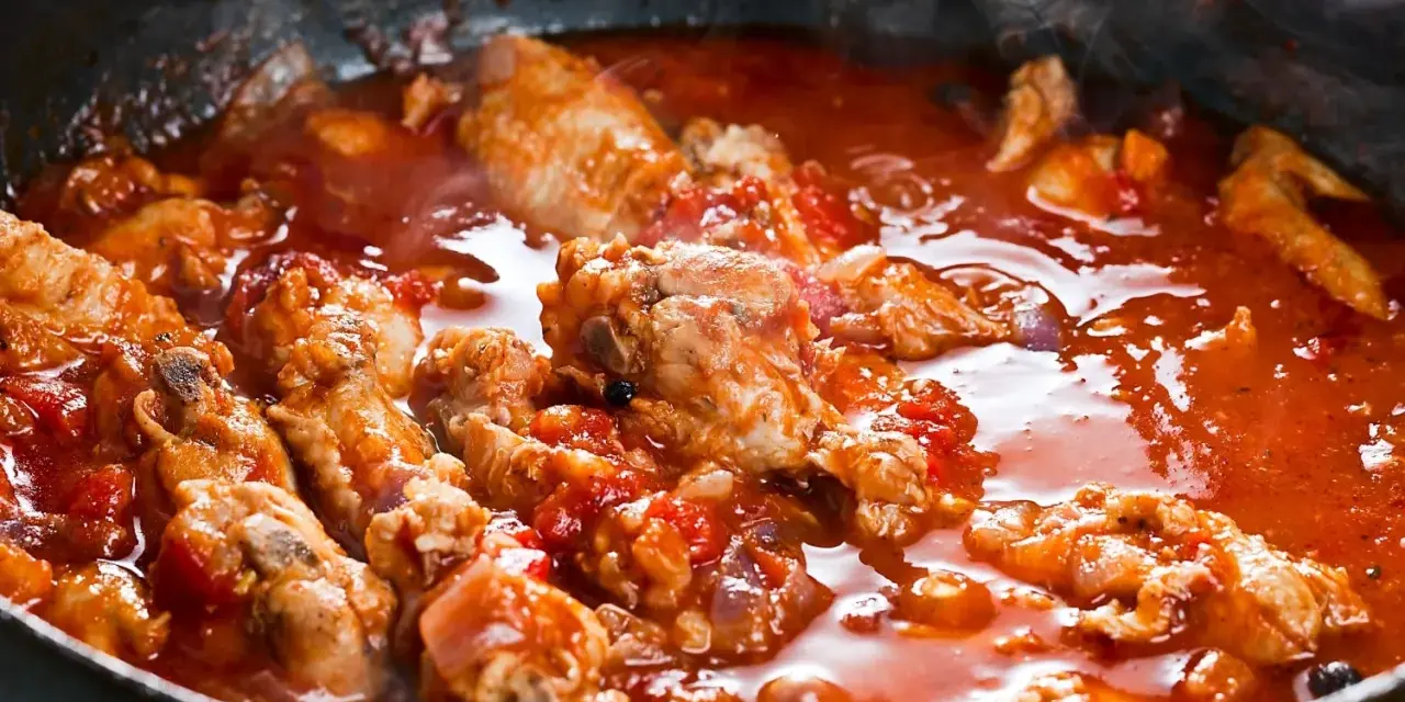 Succulenta carne alla pizzaiola che sobbolle in padella, sprigionando un invitante vapore. Pezzi di carne tenera immersi in un ricco sugo di pomodoro.