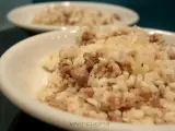 Risotto alla mantovana ingredienti: riso cremoso con salsiccia sbriciolata, servito in una ciotola bianca.