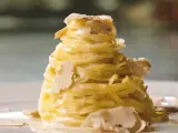 Un nido di pasta al tartufo, condita con una cremosa salsa e guarnita con scaglie sottili di tartufo bianco.