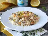 Un invitante risotto allo scoglio, ricco di cozze, gamberi e calamari, guarnito con scorza di limone.