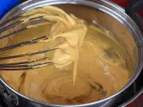 Una frusta raccoglie una crema densa e dorata, pronta per diventare uno zabaione freddo.