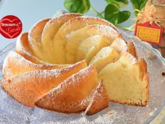 Un soffice ciambellone allo yogurt greco, spolverato di zucchero a velo, pronto per essere gustato.