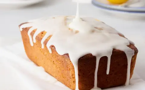 Dolce loaf ricoperto da una glassa lucida, preparata con zucchero a velo e acqua, che cola sui lati.