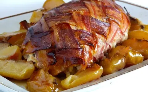 Arista di maiale alla birra, un piatto fatto in casa da Benedetta, avvolta in pancetta croccante e servita con patate dorate.