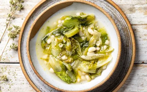 Scarola e fagioli fatto in casa da Benedetta, un piatto semplice e gustoso, servito in una ciotola rustica su un tavolo di legno.