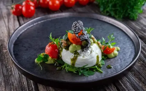 Burrata affumicata con pomodorini, crema di piselli, pinoli e pesto. Un piatto che esalta gli abbinamenti perfetti.