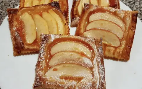Deliziose sfogliatine di mele, dorate e lucide, cosparse di zucchero a velo. Un dolce invitante e profumato.