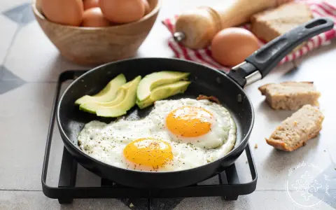 Due uova alla griglia con avocado e pane tostato, un inizio perfetto per la giornata.