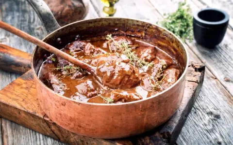 Succulento brasato ricetta semplice in una pentola di rame, pronto per essere servito.