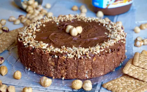 Torta Nutella 3 ingredienti: golosa e facile, con croccante base di biscotti e nocciole, ricoperta di crema alla nocciola e granella.